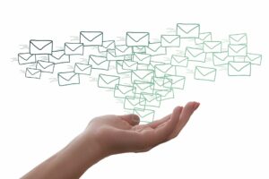 Een hand met allemaal envelopjes als symbool voor mailings en nieuwsbrieven